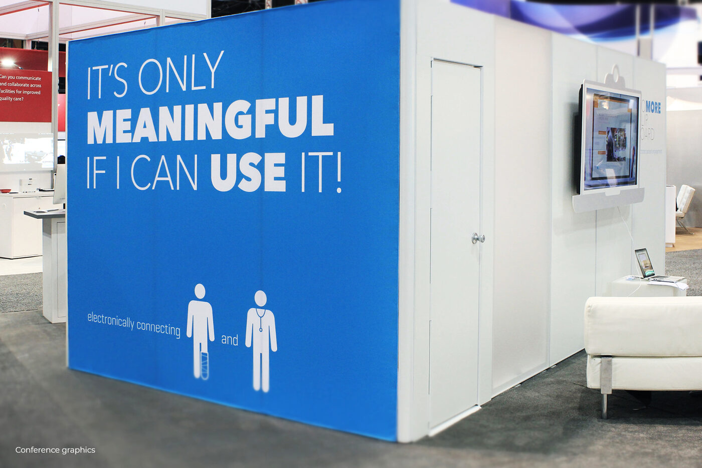 Wider view of the booth meeting space and wall signage